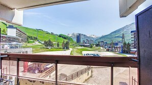 Un balcón con vistas a un pueblo, edificios y montañas.