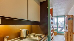 Una cocina moderna con electrodomésticos de acero inoxidable, una tetera y un lavabo.
