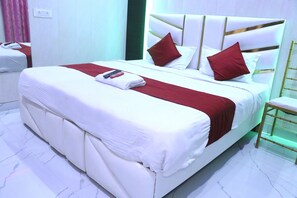 Une chambre d’hôtel avec un grand lit, une table de chevet et une chaise.