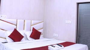 Quarto de hotel moderno com uma cama grande, ventilador de teto e iluminação LED.