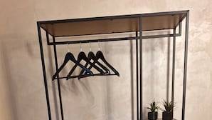 Un estante metálico con varios compartimentos, incluyendo un estante inferior y tres superiores con plantas en macetas y objetos decorativos.
