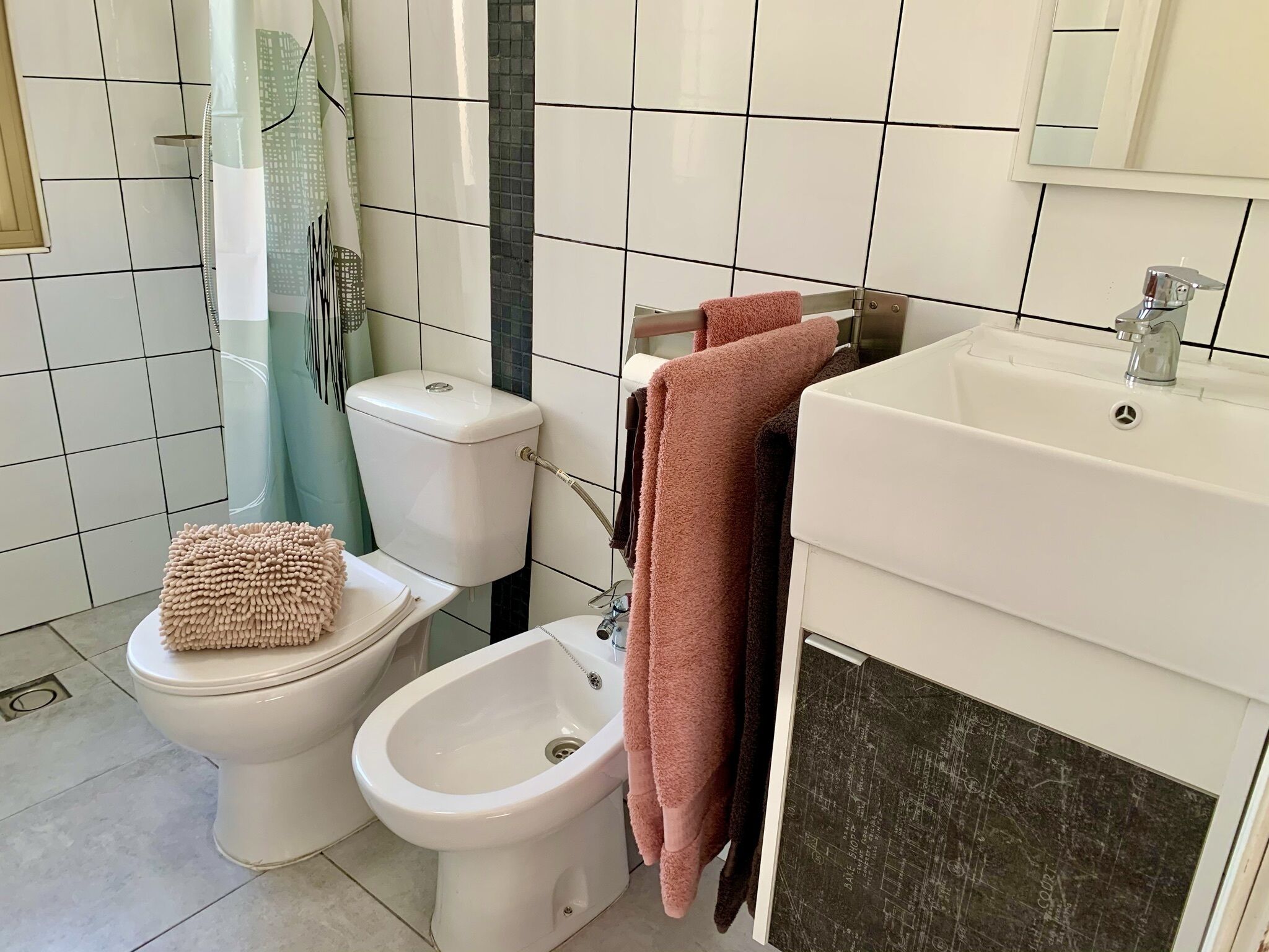Een badkamer met toilet, hygiëneschuimer en wastafel.