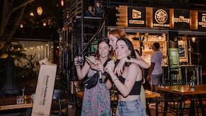 A restaurant with outdoor seating, a staircase, and a sign for a cocktail bar and roastery.