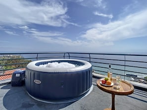 An inflatable hot tub on a balcony with a view of the sea, a bottle of wine, and a fruit plate. - Villa Formosa View by Atlantic Holiday (Funchal)