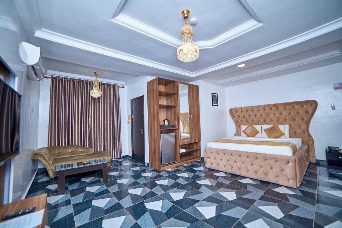 Ein Hotelzimmer mit Bett, Sofa, Kleiderschrank und Fernseher.