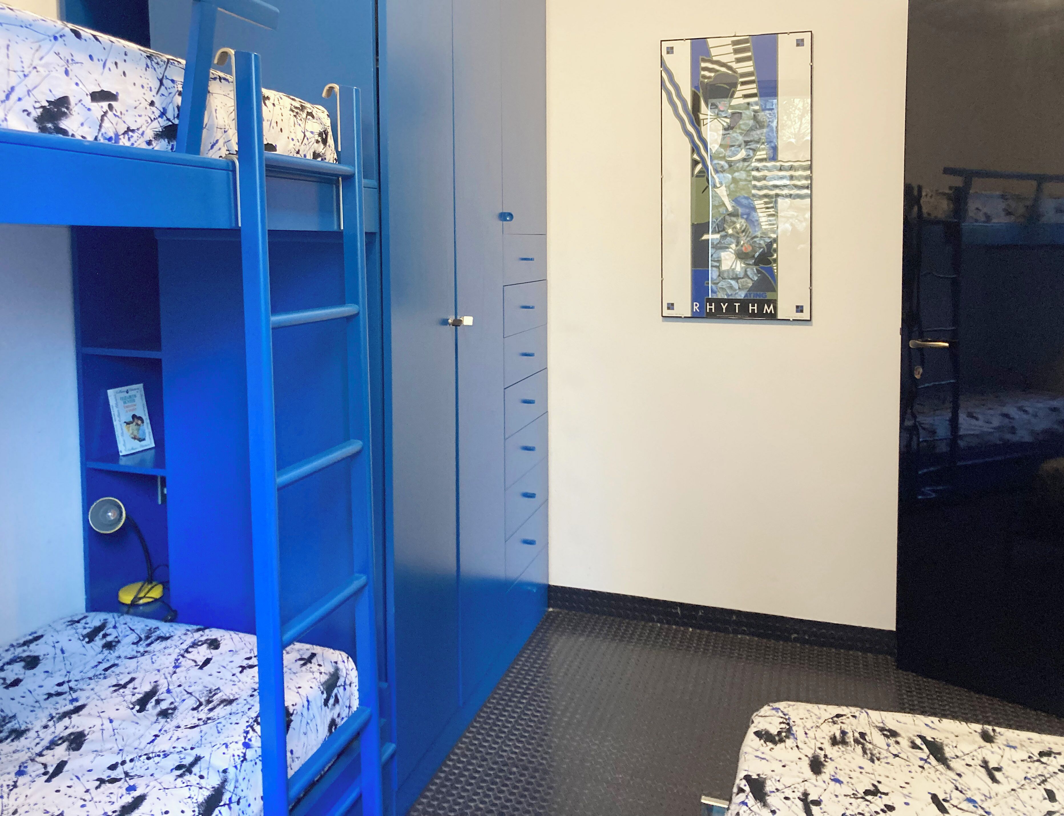 Ein Zimmer mit Etagenbetten, einem Kleiderschrank und einem Bild an der Wand.