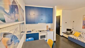 Frigorífico, placa de cocina, utensilios de cocina y mesa de comedor