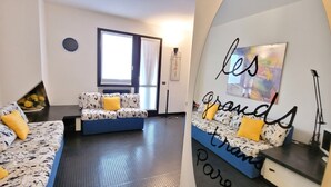 Una sala de estar moderna con un conjunto de sofá, una mesa de centro y una pared decorada con un cuadro.