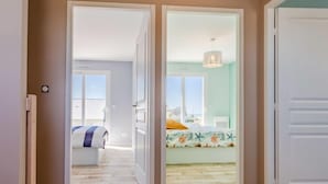 Una camera d'albergo con un letto, vista sul mare e un balcone.