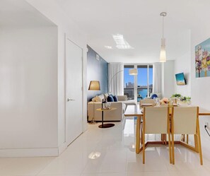 Un salon moderne avec un canapé, une table à manger et des chaises.