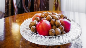 Una mesa de comedor con un plato de frutas y nueces.