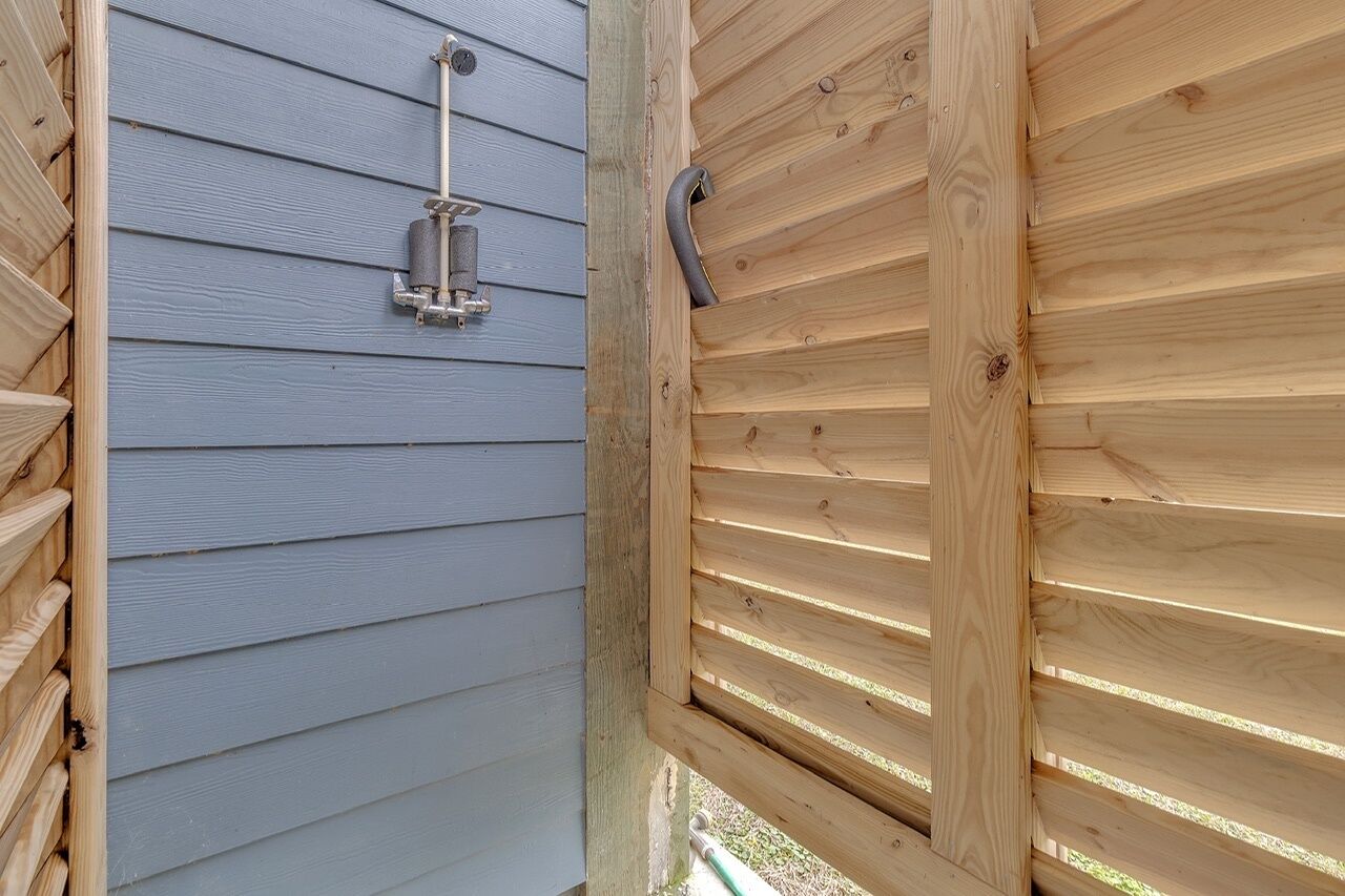 A wooden structure with horizontal slats and a metal fixture attached to a wall with horizontal siding.