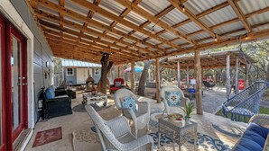 A covered outdoor patio with wicker furniture, a swing chair, and a Coca-Cola cooler. - Roz's Rusted Porch - Whitewater Amp, River, Lake (Canyon Lake)