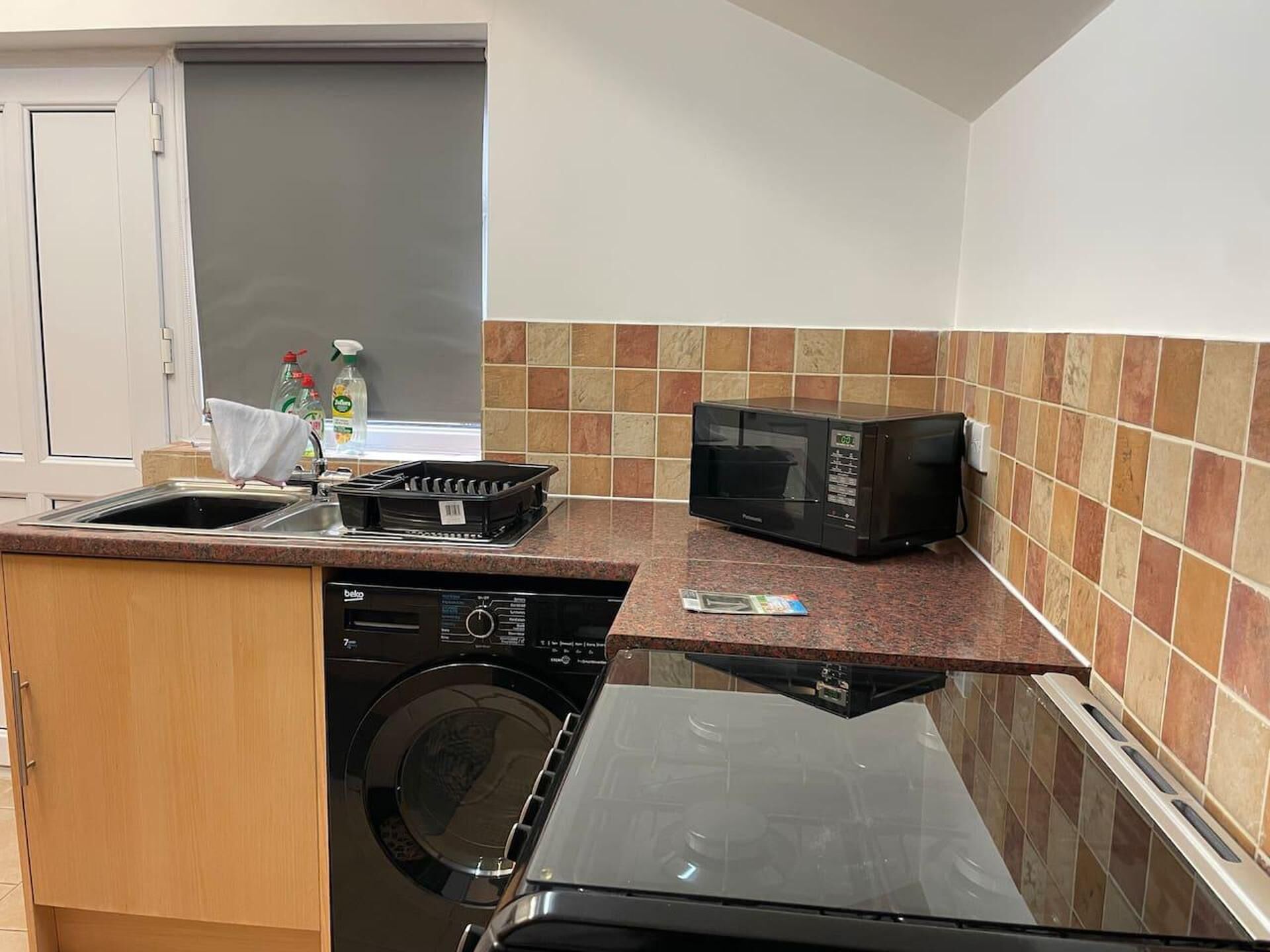 A compact kitchen with a dishwasher, microwave, and oven.