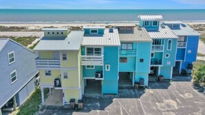 A row of beach houses with a view of the ocean.