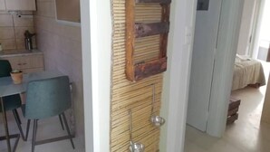 Una habitación con zona de comedor, cama y baño.