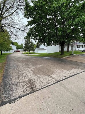 A residential street with houses, a driveway, and a mailbox. - 1 Bed 1 Bath Apartment at Northtowne Apartments! (Tomah)