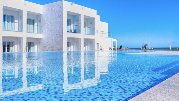 A modern hotel with a pool, balconies, and a view of the sea. - Amber El Fell- Boutique Hotel (Hammamet)