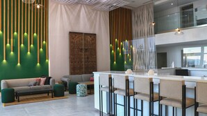 A modern kitchen with a bar area, a sofa, and a patterned wall. - Amber El Fell- Boutique Hotel (Hammamet)