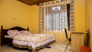 A bedroom with a bed, a desk, and a chair. - Comfort Apartment  (Kigali)