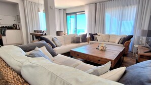 Un salon moderne avec un ensemble de canapés, une table basse en bois et un téléviseur.