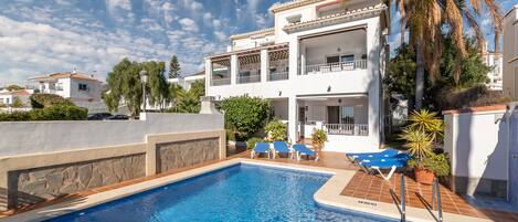 Et oppvarmet basseng og solsenger