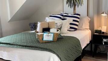 A bedroom with a bed, a nightstand, a lamp, a picture of a palm tree, and a caution sign on the wall.