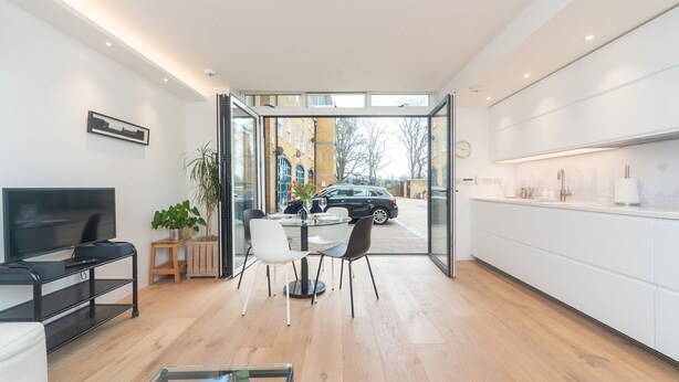 Una cocina moderna con comedor, televisión y vistas a la calle.