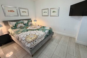 A bedroom with a bed, nightstands, a lamp, and framed fish pictures on the wall. - 3/3 Duplex for 6+Shared Heated Pool, Tiki Bar BBQ (Hollywood)