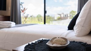 A neatly made bed with white bedding, a black throw blanket, and a decorative bowl on a woven placemat. - Xentum Residences - Dreamed Condo (Tulum)