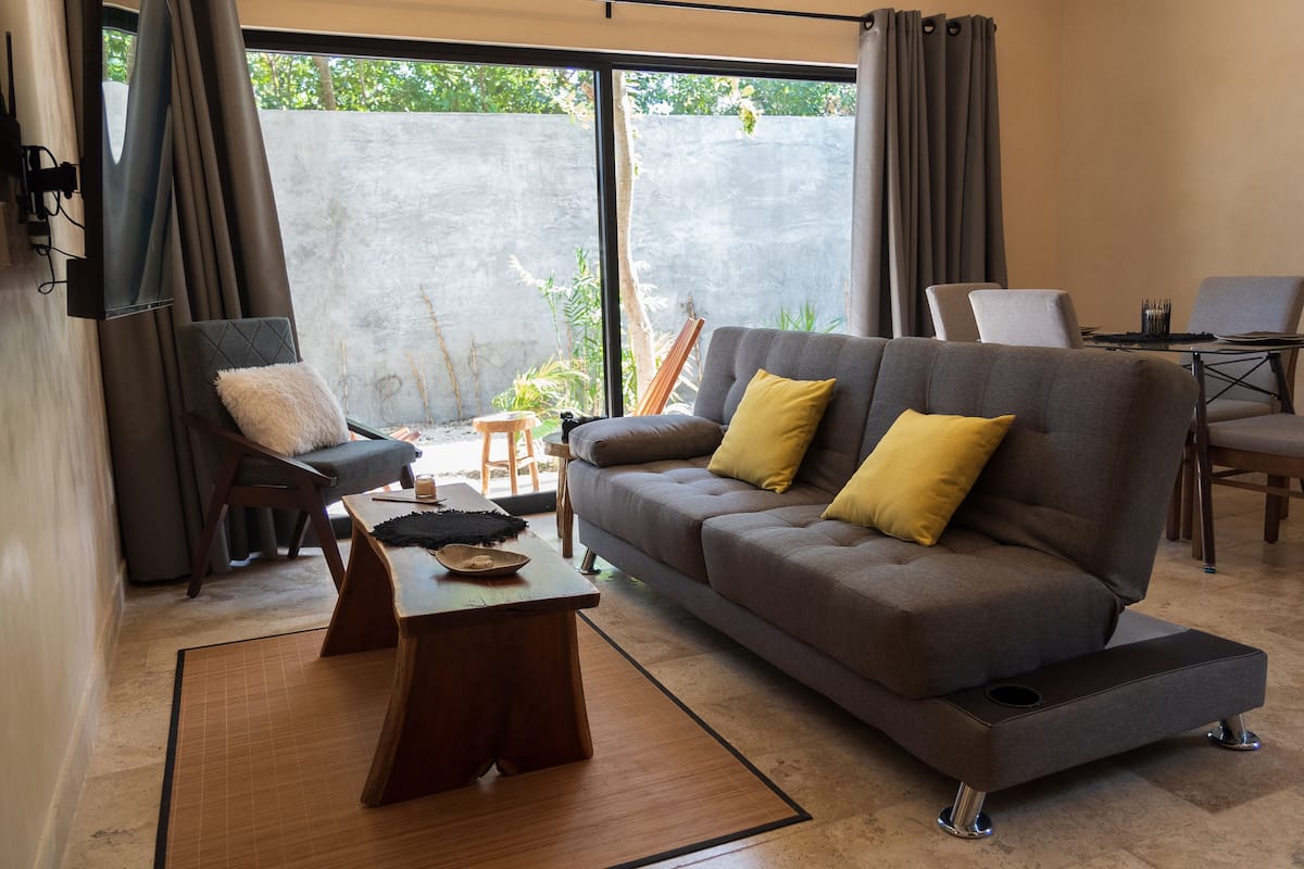 Una sala de estar moderna con un sofá, sillones y una mesa de centro.