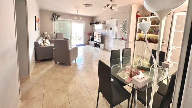 A spacious living area with a glass dining table, comfortable seating, and a TV in the background. - Ganesh House 2 Bedrooms (Tías)
