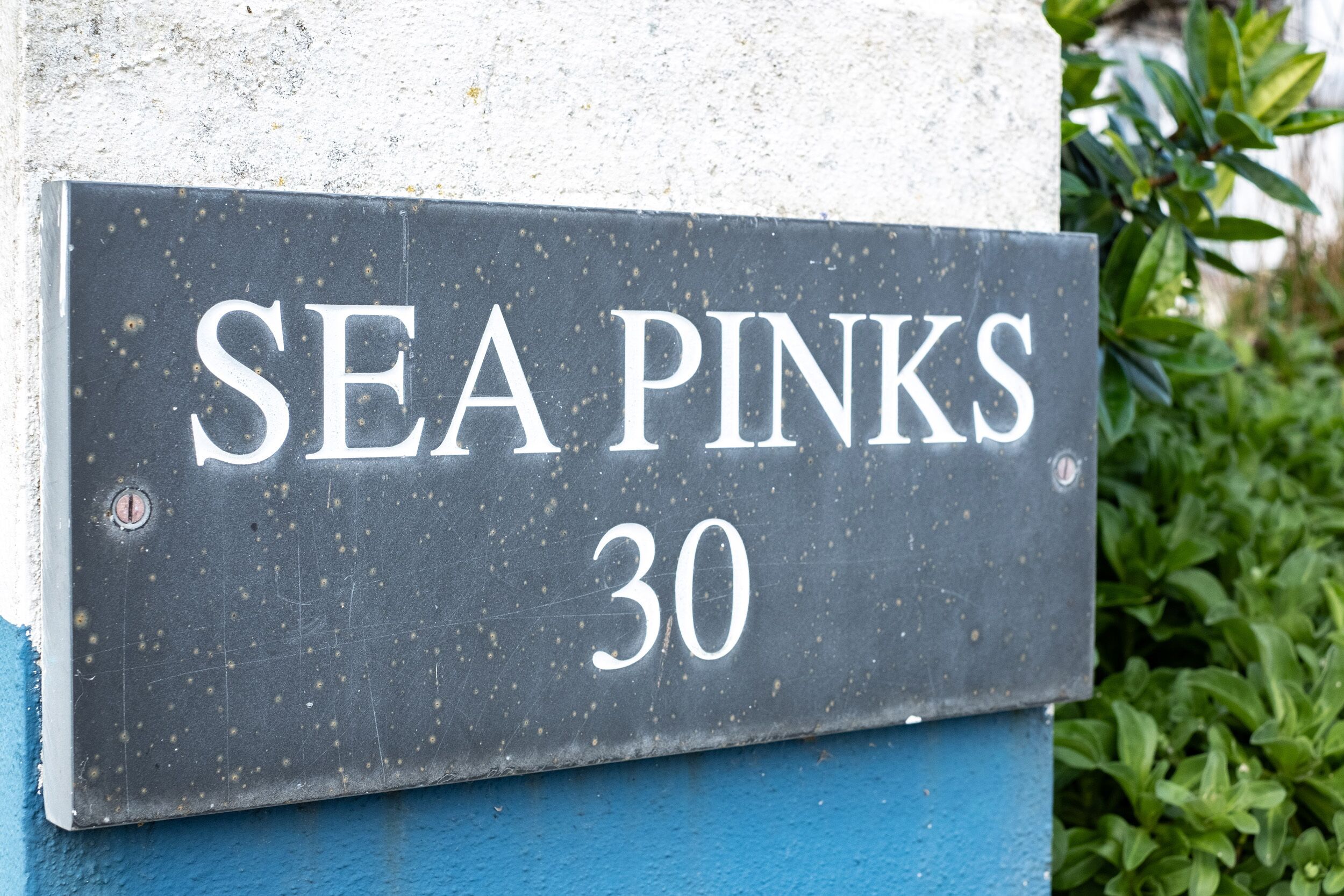 A house number sign with "SEA PINKS 30" written on it.