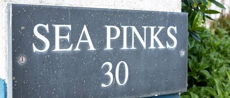 A house number sign with "SEA PINKS 30" written on it.