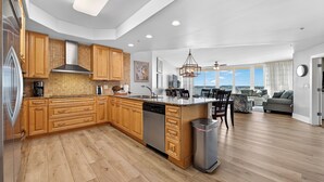 Une cuisine moderne avec des meubles en bois, un lave-vaisselle et un grand îlot central.