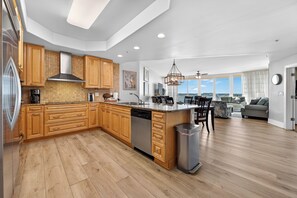 A modern kitchen with wooden cabinets, a dishwasher, and a large island.