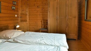 Une pièce en bois avec un lit, une chaise et une armoire.