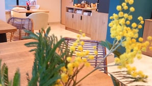 A modern interior with a dining area, kitchen, and a large window. - Intense Boutik Hôtel (Port-Vendres)