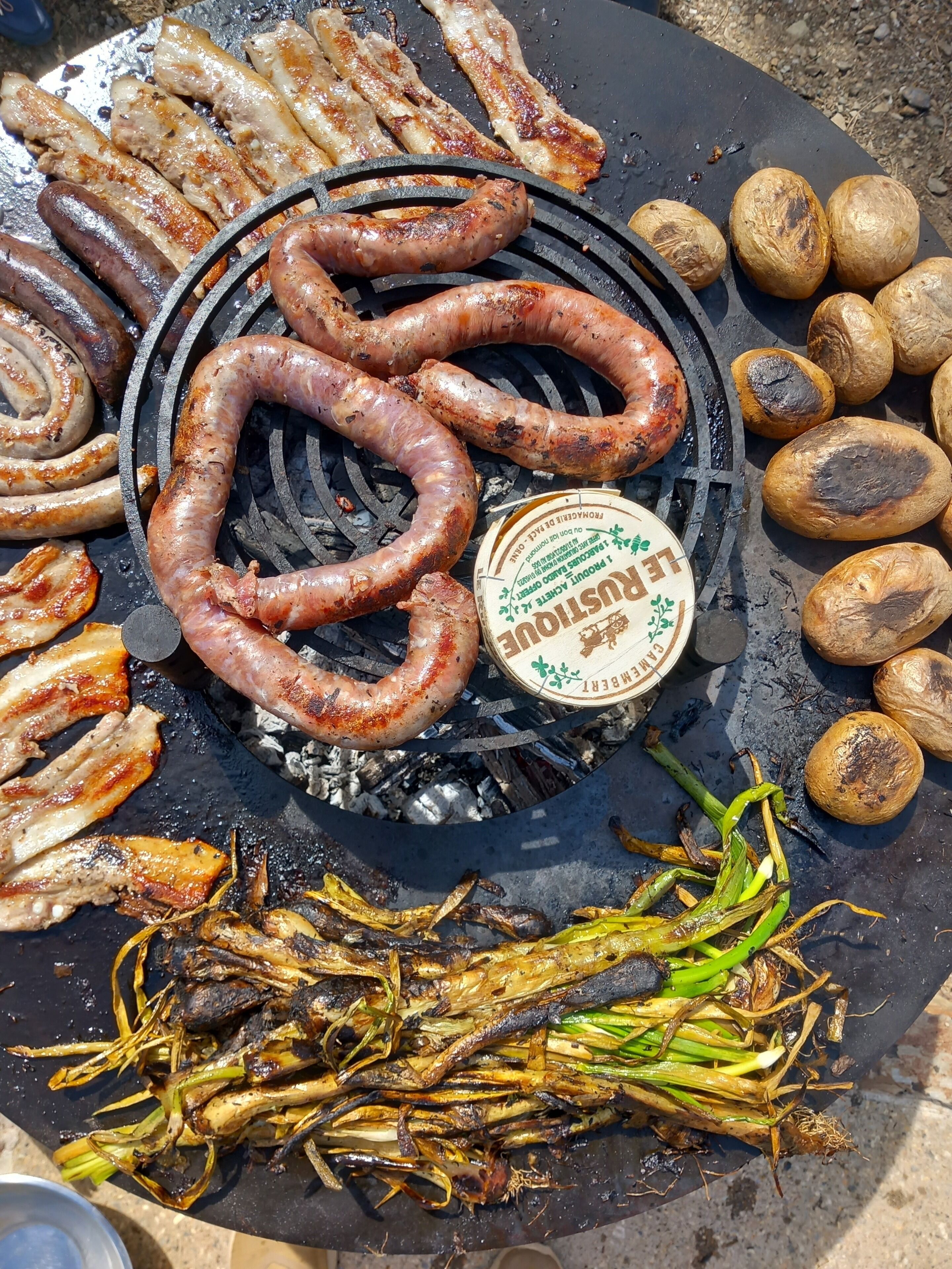 Ein Grill mit verschiedenen Fleisch- und Gemüsesorten, die zubereitet werden.