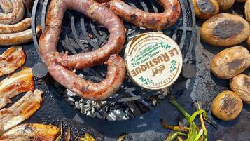 Ein Grill mit verschiedenen Fleisch- und Gemüsesorten, die zubereitet werden.