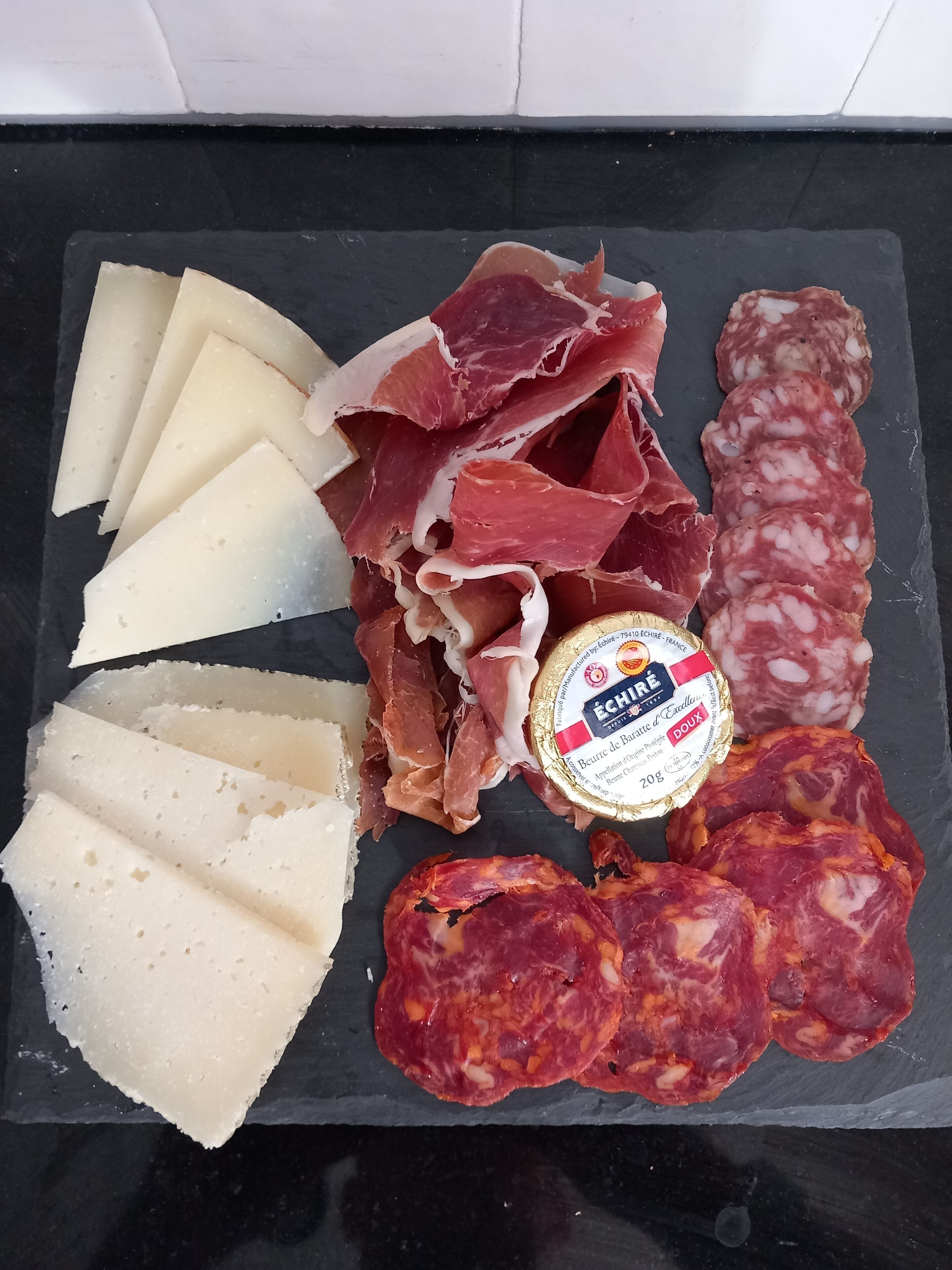 A charcuterie board with various meats and cheeses.
