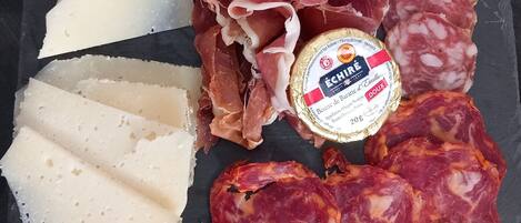 A charcuterie board with various meats and cheeses.