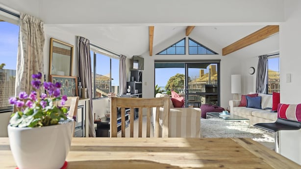 Un salón espacioso con una mesa de madera, un sofá y un comedor. Una ventana grande ofrece vistas al exterior.