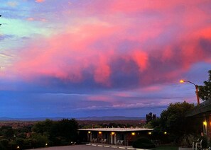 A building with a covered outdoor seating area and a view of the cityscape in the background. - The View Motel (Cottonwood)