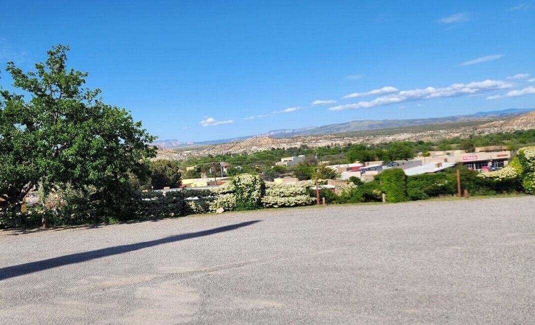 A parking lot with a view of a town and mountains in the distance.
