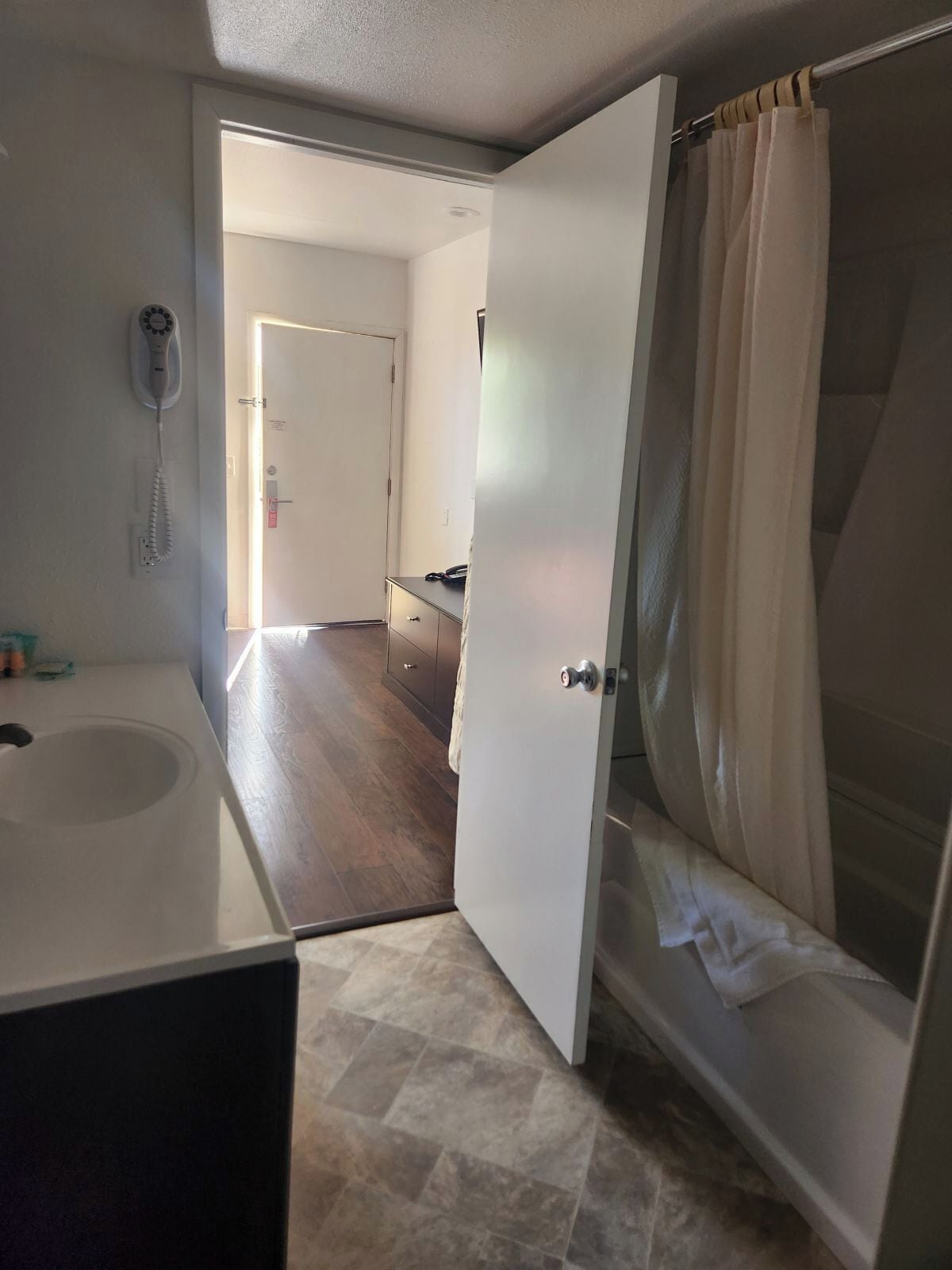Un baño con bañera, cortina de ducha y retrete.