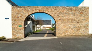 A stone archway leading to a building with a sign reading "LA STERNE 11". - Ti Kréol - 5 minutes des plages (Saint-Nic)