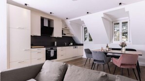 Une cuisine moderne avec un coin repas, comprenant un canapé et des fauteuils, ainsi qu’une fenêtre offrant une vue agréable.