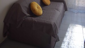 A room with a bed, a wall-mounted air conditioner, and framed pictures.