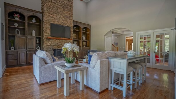 A spacious living area with a stone accent wall, built-in shelving, a fireplace, and a dining area with bar stools. - Hidden Haven on 9 acre, pond, barn and more, sleeps 20 (Stanfield)